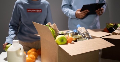 Volunteer putting together box of food and drink to give out